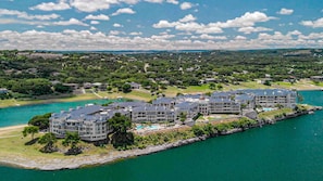 A coastal resort with multiple buildings, a beachfront, and a large body of water. - Sunset & Lakeview from Castle Turret on The Island (Lago Vista)