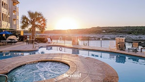 A pool area with a hot tub, lounge chairs, and a view of the sunset over a body of water. - Sunset & Lakeview from Castle Turret on The Island (Lago Vista)