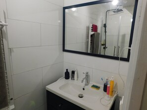 Een douche, handdoeken, zeep, toiletpapier