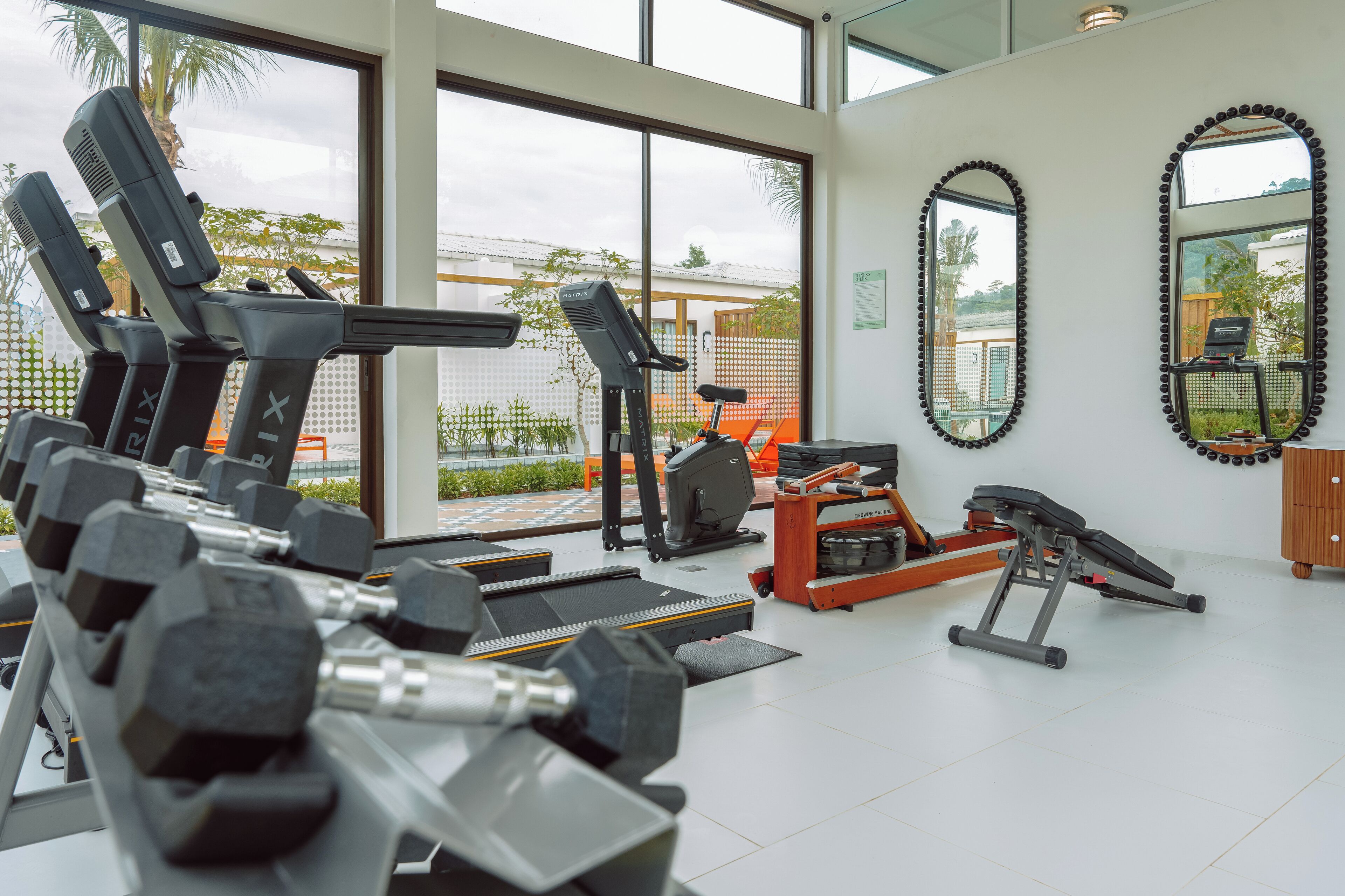 Ein Fitnessstudio mit Laufbändern, Hanteln und Trainingsgeräten.