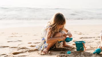 Un bambino gioca con la sabbia sulla spiaggia.