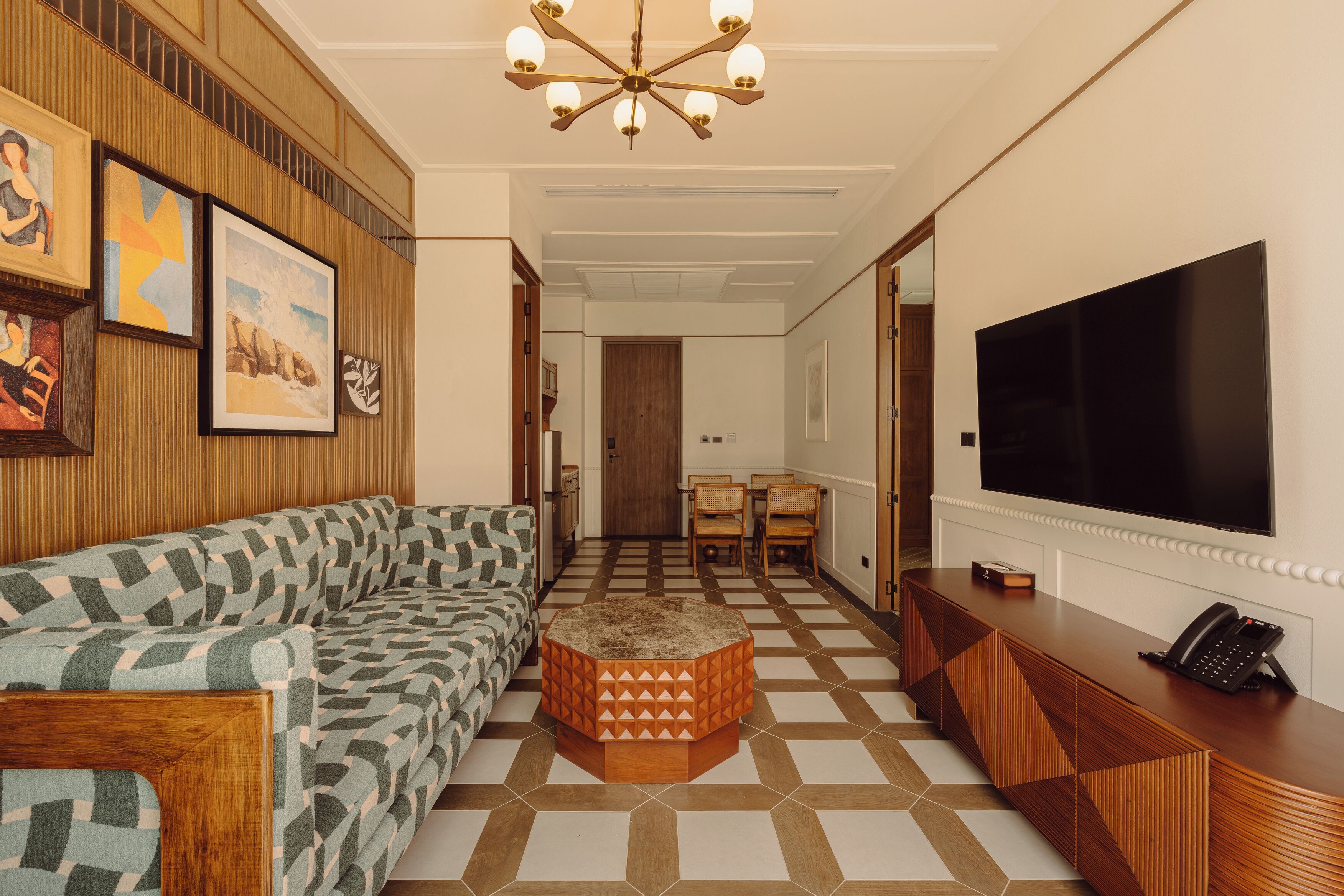 Una sala de estar moderna con un sofá estampado, una mesa de centro de madera y un televisor de pantalla plana sobre un mueble de madera.