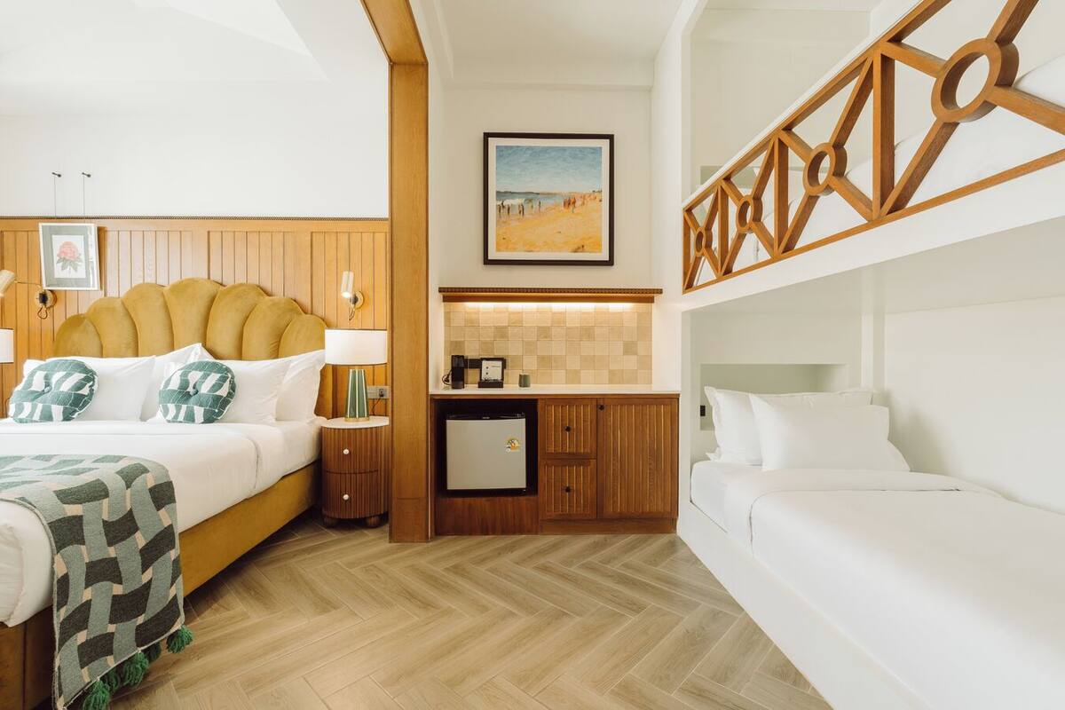 Une chambre d’hôtel avec un lit, une petite kitchenette, une salle de bain et vue sur la plage.