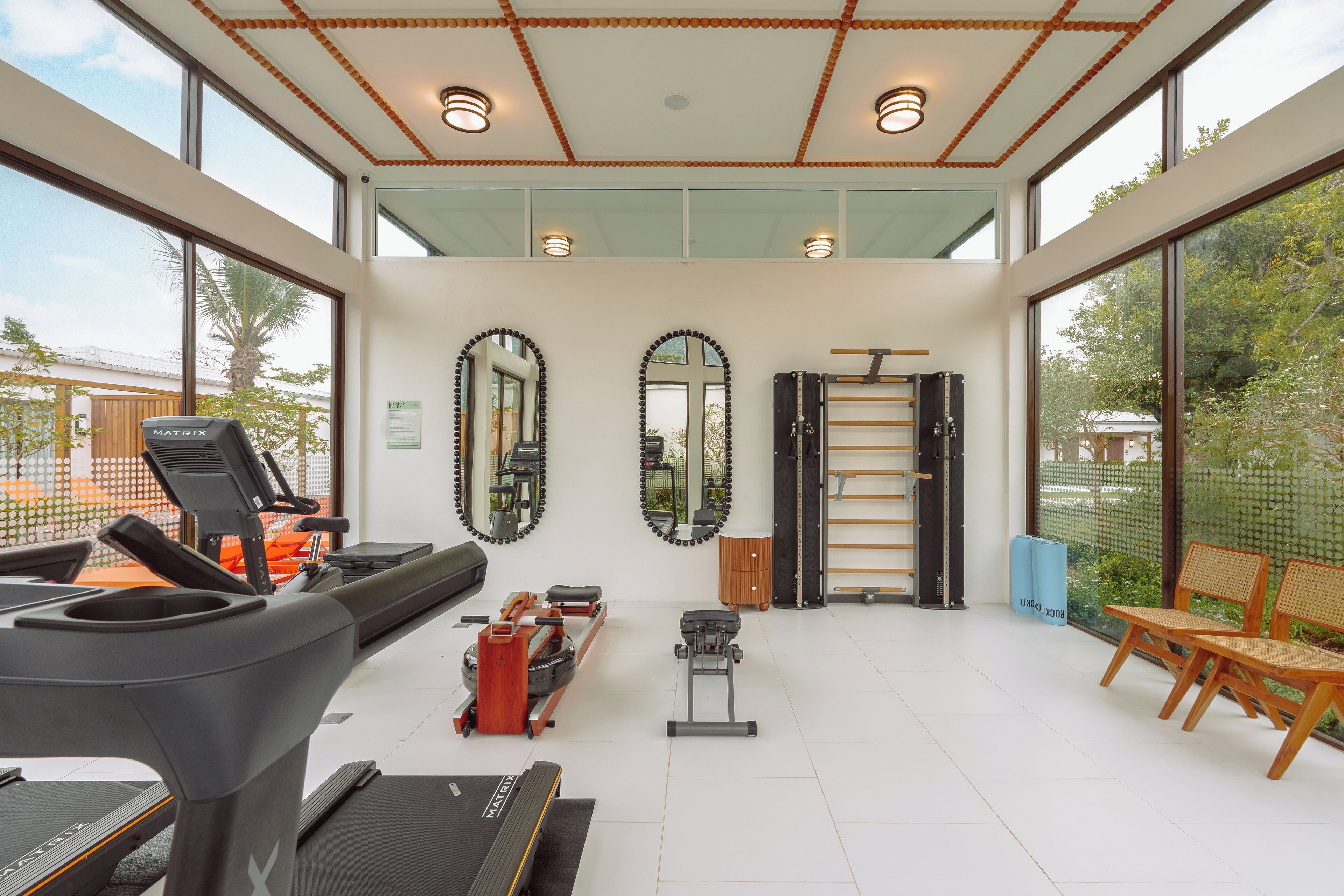 A modern gym with treadmills, a rowing machine, and exercise equipment.