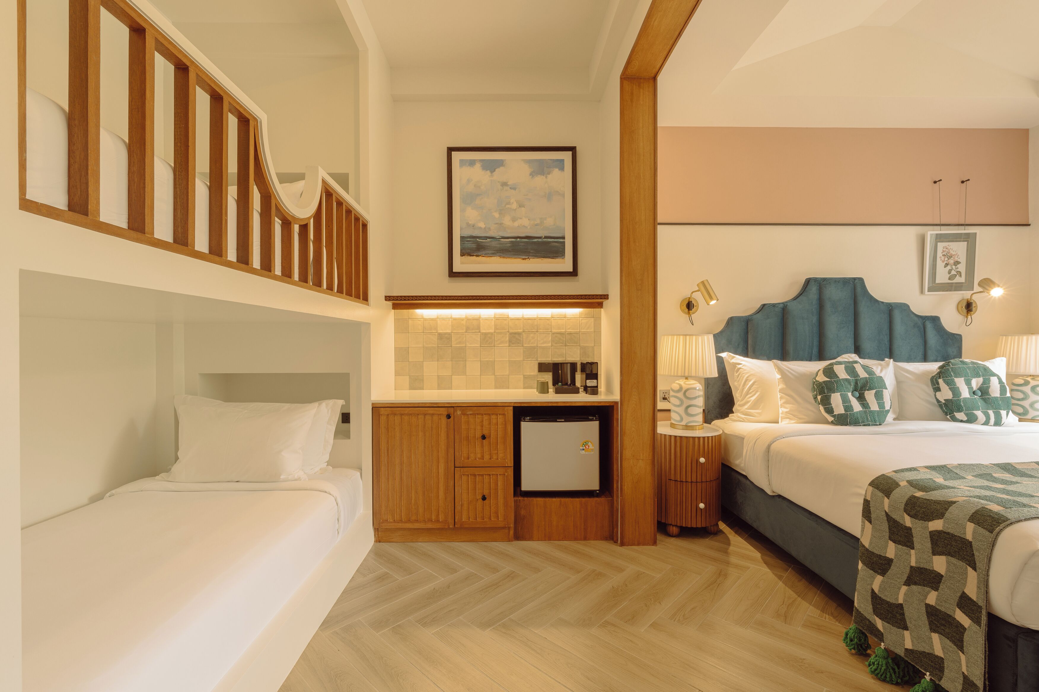 Una habitación de hotel con cama, una kitchenette pequeña, una escalera de madera y vista al mar.