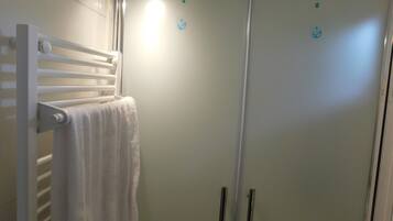 Een douche, handdoeken, zeep, toiletpapier