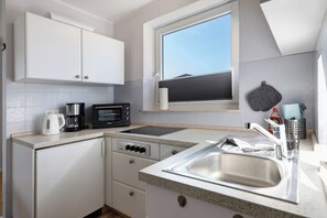 Fridge, microwave, oven, stovetop - Studio Apartment 'Ferienwohnung Friesenkoje' with Private Terrace, Shared Garden and Wi-Fi (Nordstrand)