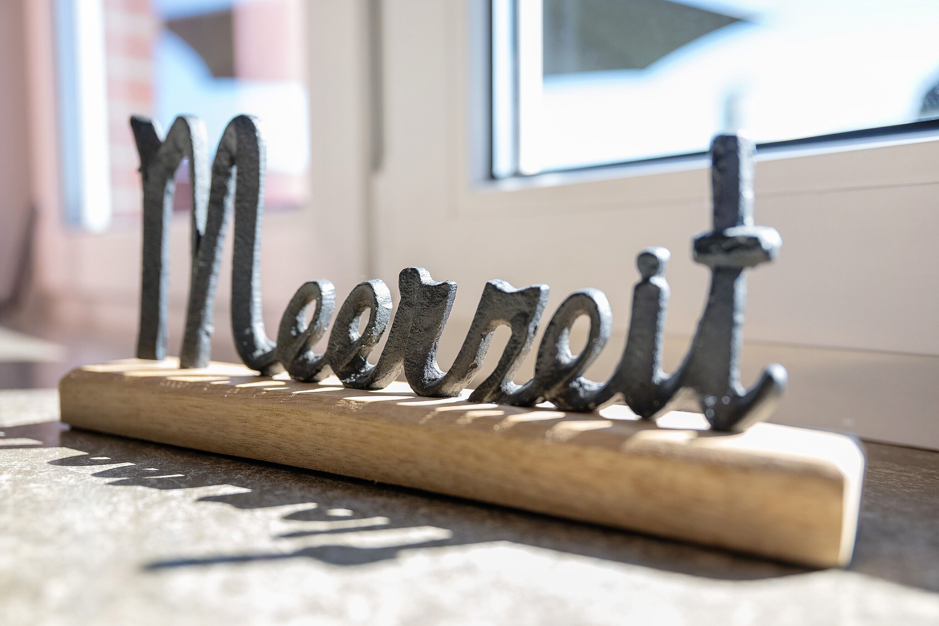 Un letrero de metal con la palabra 'Meirei' sobre una base de madera.
