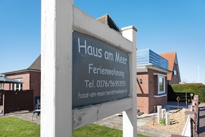 Placa de identificação de propriedade residencial chamada 'Haus am Meer' com informações de contato.