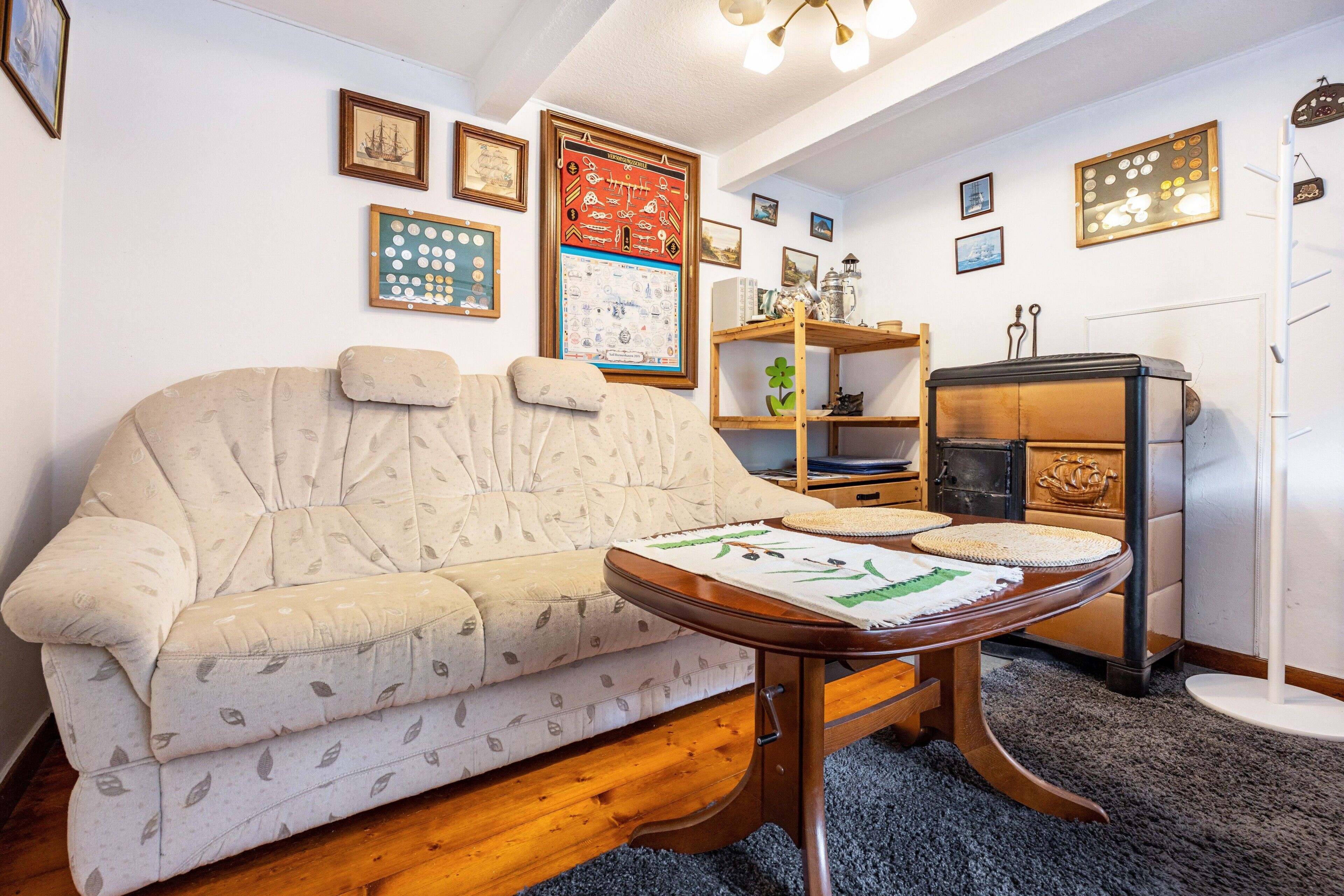 Ein Wohnzimmer mit einer Couch, einem Holztisch, einem Bücherregal und einer Heizung.