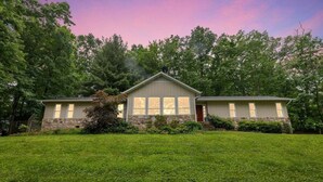 A two-story house with a stone foundation, large windows, and a well-maintained lawn. - Greene Hills Vista Cottage (Stanardsville)