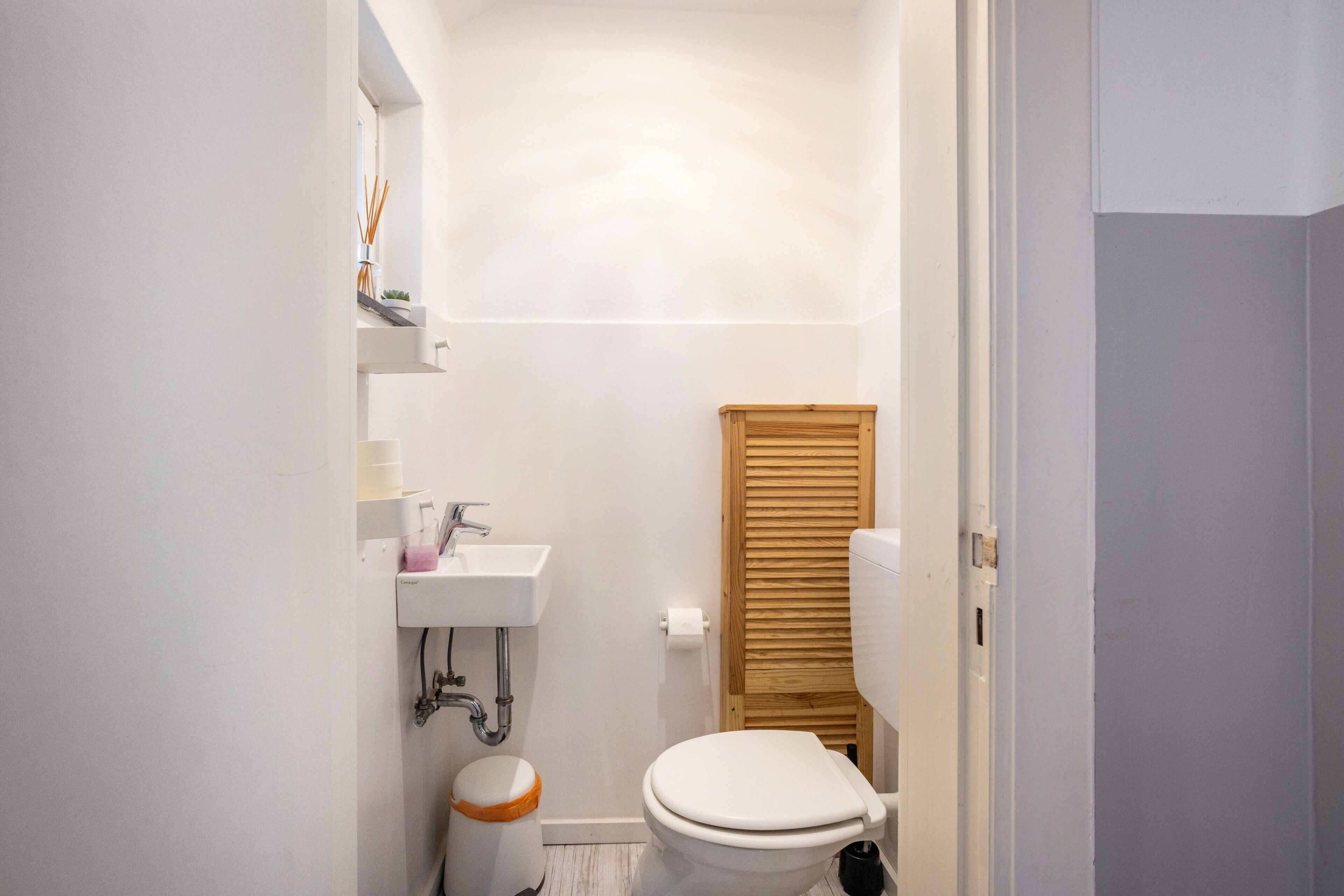 Un bagno piccolo con il water, un lavandino e un armadietto in legno.