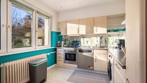 A modern kitchen with a dishwasher, oven, and a view of the outside. - Holiday Home 'Sandstrand' with Private Terrace, Garden, and Wi-Fi (Timmendorfer Strand)