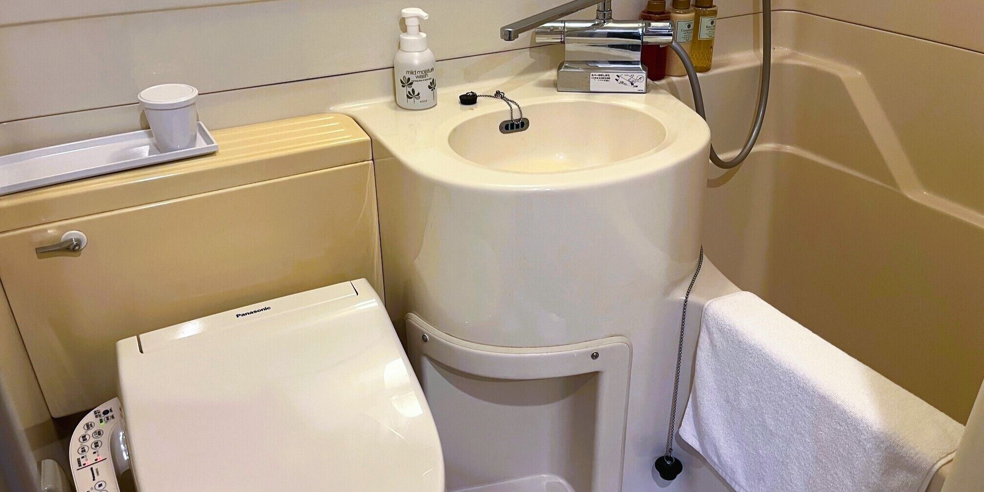 A bathroom with a toilet, sink, and shower.