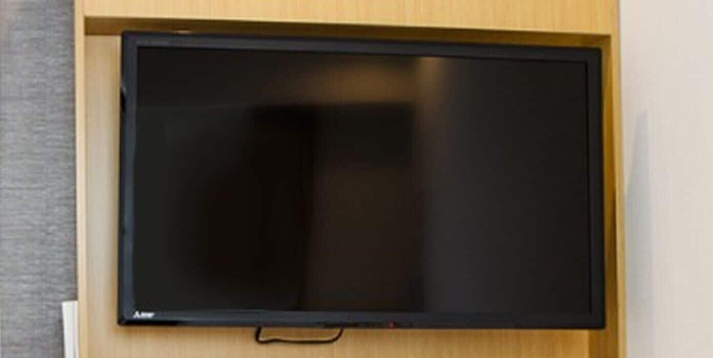 A flat-screen TV mounted on a wooden wall.
