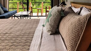 Ein Schlafzimmer mit einem großen Bett, einer Couch und einem Balkon mit Holzmöbeln.