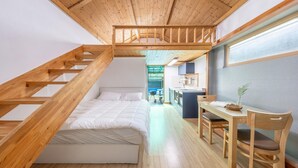 A loft-style bedroom with a wooden staircase, a bed, a desk, and a chair. - Boryeong Hiddenvillage Dokchae Poolvilla (Boryeong)