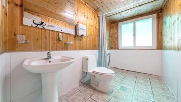 A bathroom with a sink, toilet, and a window with a view.