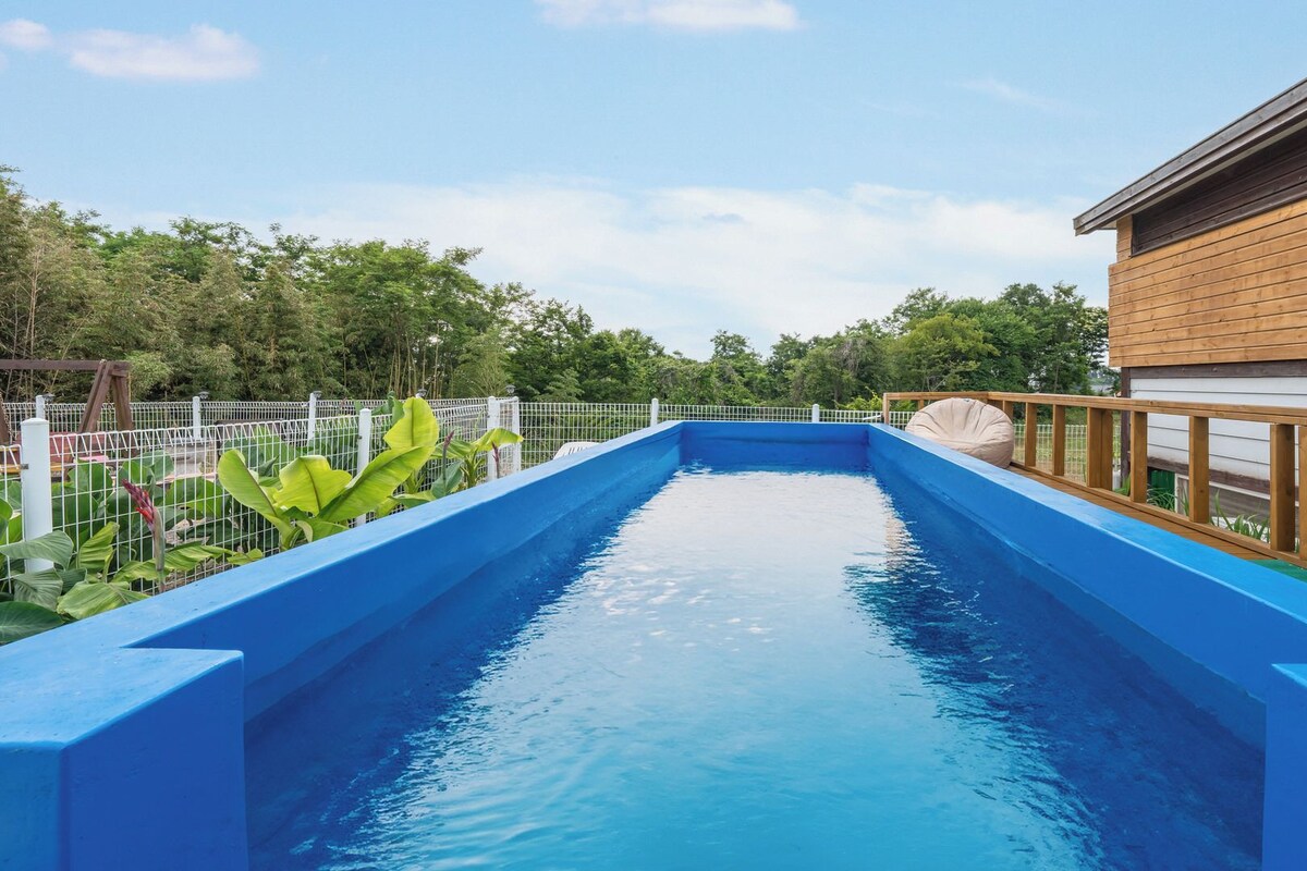 A swimming pool with a wooden deck and a white fence.