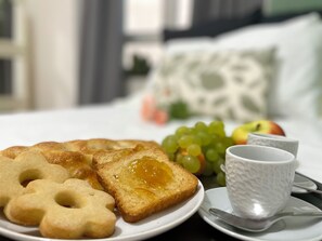 A breakfast setting with toast, cookies, grapes, and a cup on a plate. - Happy Family Apartments Andreana (Genoa)