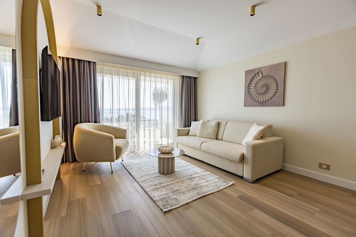Un salon moderne avec un canapé, un fauteuil et une table basse ronde.