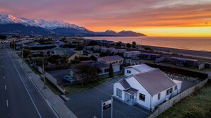 A residential area with houses, a road, and a body of water with mountains in the background. - Central | Beach Nearby | Parking - KK27622 (Kaikoura)