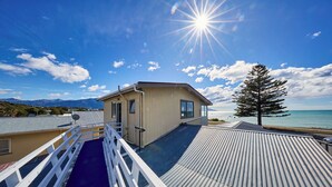 A building with a metal roof, a small window, and a white railing. - Waterfront | Handy Location | Affordable | Unit 1 - KK41164 (Kaikoura)