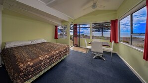Una stanza con un letto, una scrivania e vista sull'oceano.