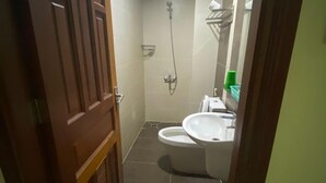 A narrow hallway leading to a bathroom with a toilet, sink, and shower. - Hoang Tay 1 Hotel by Bay Luxury (Ho Chi Minh City)