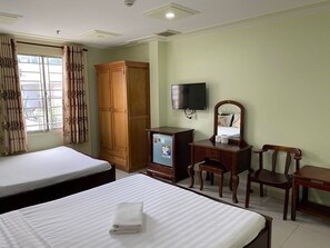 A hotel room with two beds, a wooden wardrobe, a television, a desk with a chair, and a window with curtains. - Hoang Tay 1 Hotel by Bay Luxury (Ho Chi Minh City)