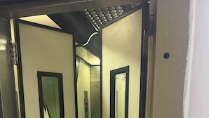 L’intérieur d’un ascenseur, avec un écran numérique et un panneau de commande.