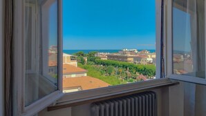 Ein Fenster mit Blick auf eine Küstenstadt, Gebäude und Grünflächen.