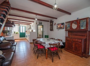 A dining area with a table, chairs, a wooden cabinet, and a staircase. - Veli Lošinj Hilltop Oasis (Mali Losinj)