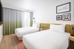 A hotel room with two beds, a desk, and a large window with curtains. There are framed pictures on the wall and a sign that says "sweet DREAMS". - Hampton By Hilton Nuneaton (Nuneaton)