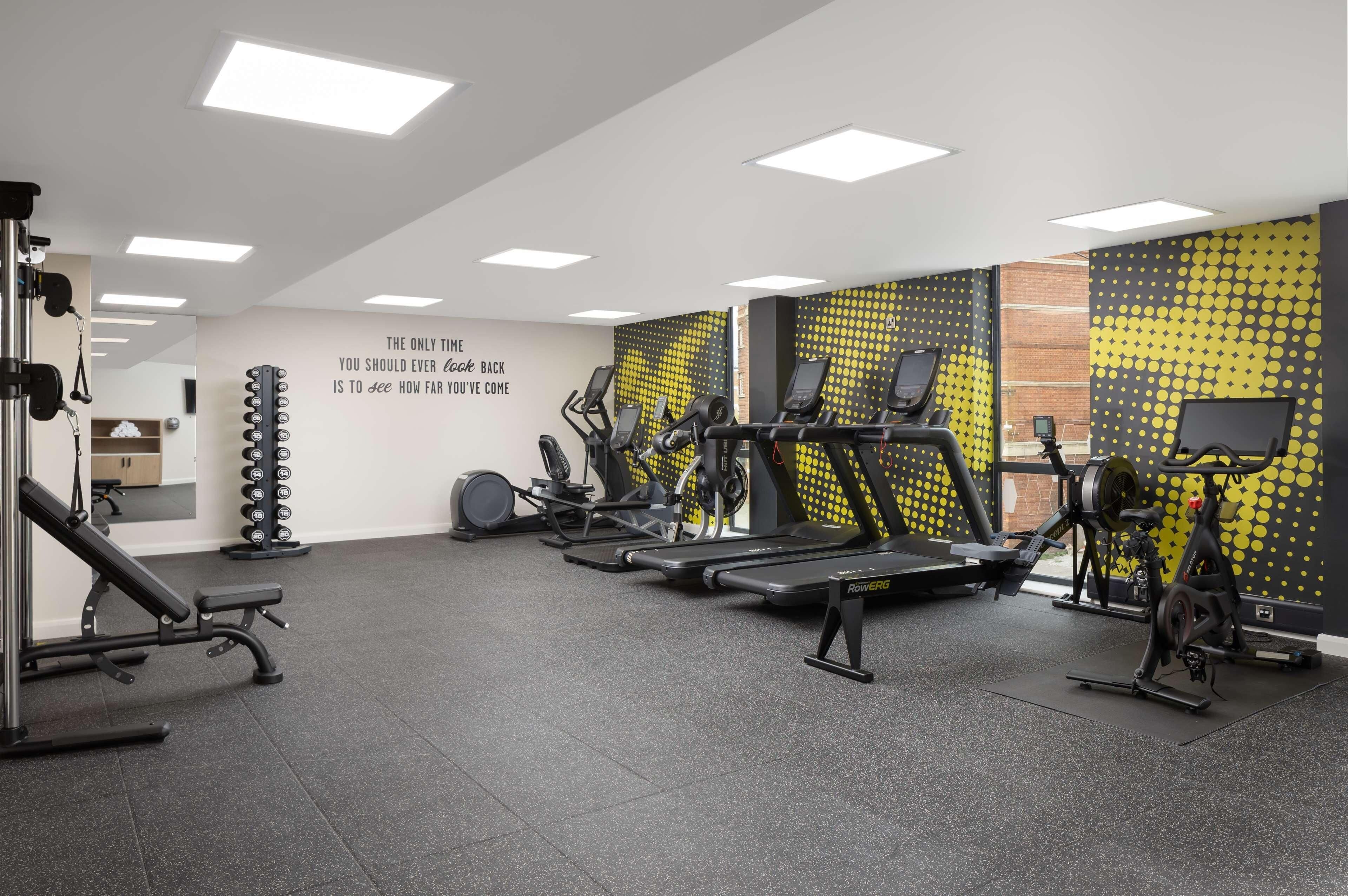 A gym with treadmills, weight machines, and a bench.