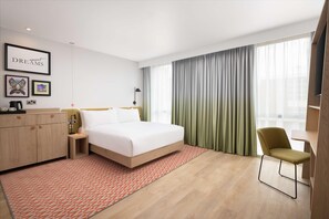 A modern hotel room with a large bed, a desk, a chair, a wardrobe, and a large window with curtains. - Hampton By Hilton Nuneaton (Nuneaton)