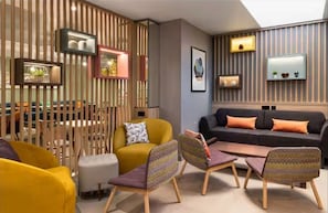 Una sala de estar moderna con un sofá, sillones, una mesa de centro y un separador decorativo.