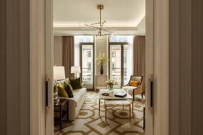 Un salon bien éclairé, avec un canapé, un fauteuil, une table basse et un vase décoratif.