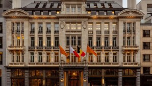 Un bâtiment historique à la façade symétrique, doté de grandes fenêtres et de balcons richement décorés.