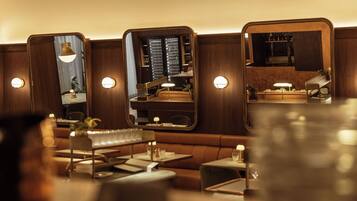 Un restaurante con paneles de madera, mesas redondas y reservados.