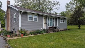 A single-story house with a front porch, a chimney, and a well-maintained lawn.
