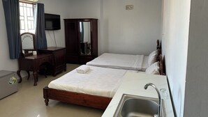 A hotel room with two beds, a desk, a mirror, a TV, and a sink. - Hoang Tay 2 Hotel by Bay Luxury (Ho Chi Minh City)