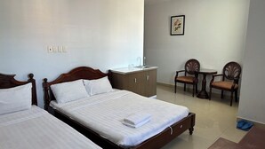 A hotel room with two beds, a small kitchenette, a dining area with a table and chairs, and a framed picture on the wall. - Hoang Tay 2 Hotel by Bay Luxury (Ho Chi Minh City)