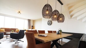 A modern dining area with a wooden table, leather chairs, and pendant lights. - Villa in Leons near Frisian Lake District (Leons)