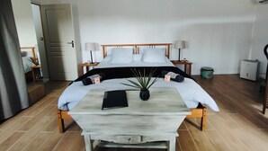 Et hotelværelse med en seng, to sengeborde, en lampe, en potteplante og et lille bord med en bog.