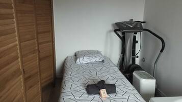 Ein Schlafzimmer mit einem Bett, einem Laufband und einem Holzschrank.