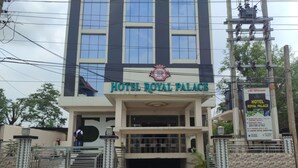 Hotel anomenat "Hotel Royal Palace" amb façana moderna, una entrada destacada i un cartell que anuncia serveis com una sala de noces i una sala de banquet.
