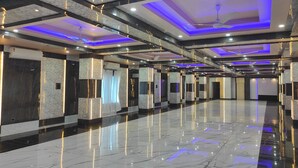 Un vestíbul d'hotel modern i espaiós, amb terres de marbre, il·luminació encastrada i un ventilador de sostre.