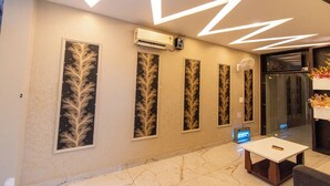 A modern lobby with a marble floor, a reception desk, and wall-mounted air conditioning units. - Hotel 7PM (Shaheed Bhagat Singh Nagar)