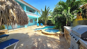 A backyard with a swimming pool, a hot tub, and a grill. - Amazing 1-bedroom Apartment 3 km From Eagle Beach (Noord)